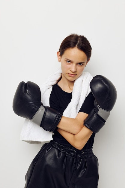 Jovem mulher com luvas pretas de boxe toalha posando esportes Estilo de vida inalterado