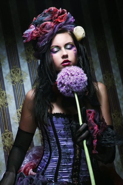 Jovem mulher com maquiagem criativa em estilo boneca com flor