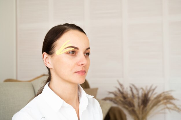 Jovem mulher com maquiagem nude, olhando para longe, luz de fundo. Gravação de rosto. Um procedimento cosmético especial para a pele.