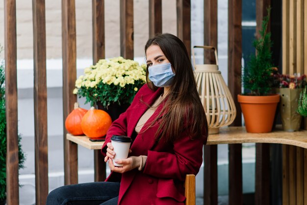 Jovem mulher com máscara facial em restaurante, novo conceito normal para proteger a pandemia de coronavírus
