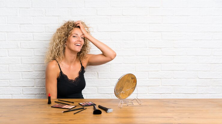 Foto jovem mulher com muita escova de maquiagem em uma mesa rindo