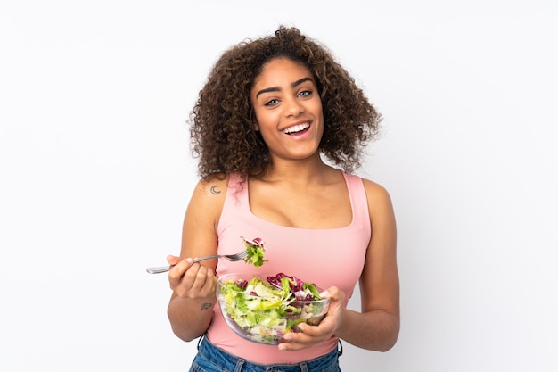 Jovem mulher com salada isolada na parede branca