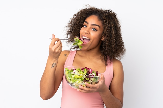 Jovem mulher com salada isolada na parede branca