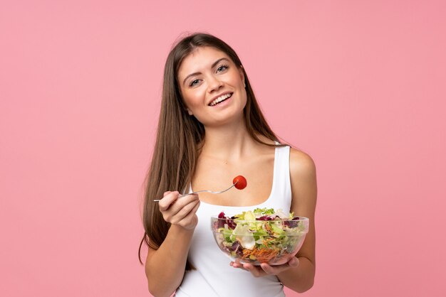 Foto jovem mulher com salada isolado parede rosa