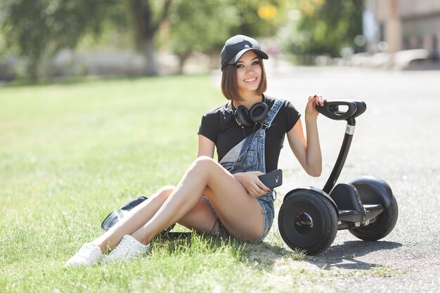 Foto jovem mulher com segway sentado ao ar livre