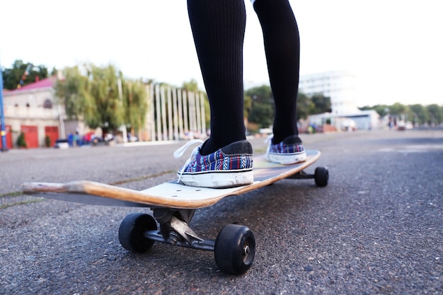 Jovem mulher com skate na estrada