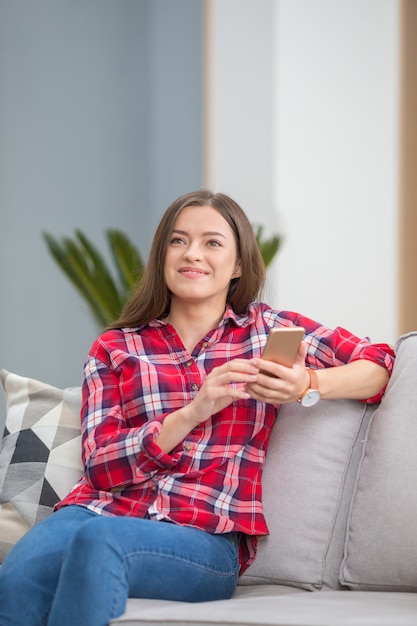 Jovem mulher com smartphone em casa