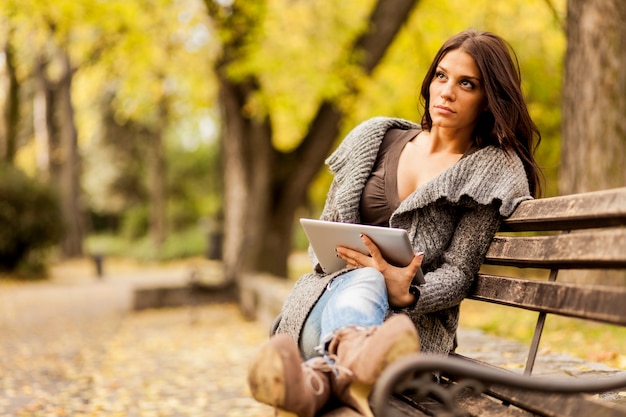 Jovem mulher com tablet no banco