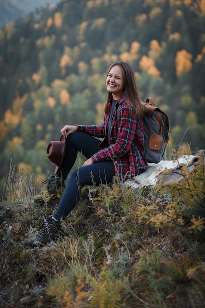 Jovem mulher com um chapéu no pico da montanha