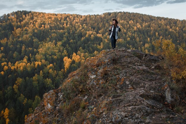 Jovem mulher com um chapéu no pico da montanha