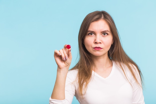 Jovem mulher com um tablet vermelho sobre fundo azul. conceito de saúde, doenças e pessoas