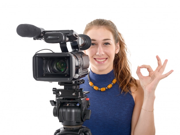 Jovem mulher com uma câmera de vídeo, pronta para filmar em fundo branco