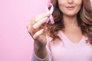 Jovem mulher com uma fita rosa em apoio à conscientização do câncer de mama
