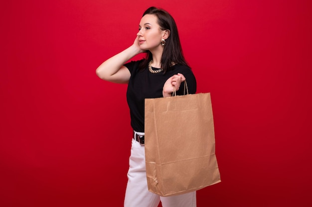 Jovem mulher com uma sacola de compras em fundo vermelho