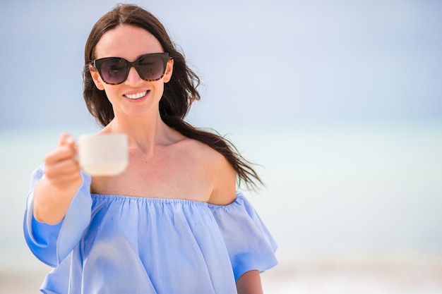 Jovem mulher com uma xícara de café quente desfrutar de férias