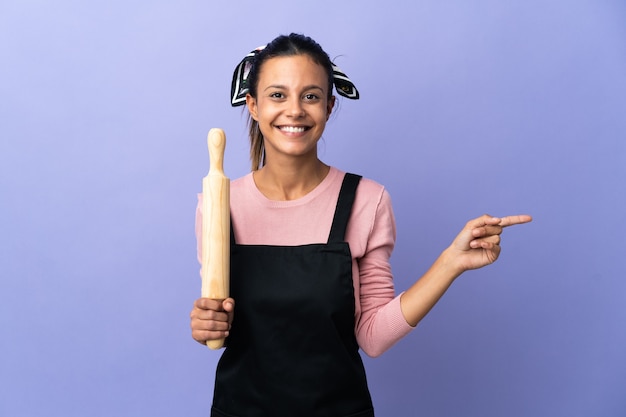 Foto jovem mulher com uniforme de chef apontando o dedo para o lado