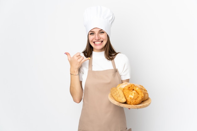 Jovem mulher com uniforme de chef em branco fazendo gesto de telefone