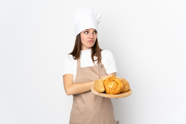 Jovem mulher com uniforme de chef isolado no branco, uma ideia