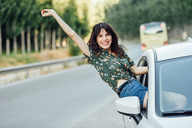 Foto jovem mulher com vestido florido entre árvores