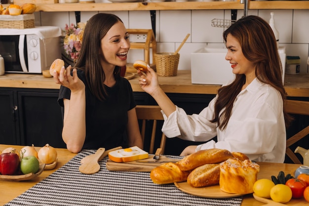 Jovem mulher comendo pizza e rindo enquanto está sentado com seus amigos em um restaurante Grupo de amigos desfrutando enquanto comem e bebem no café