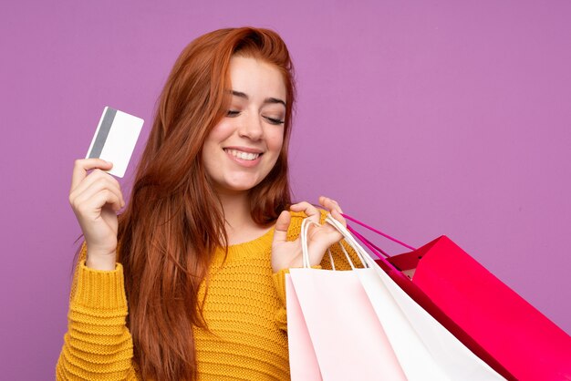 Jovem mulher comprando roupas sobre parede isolada