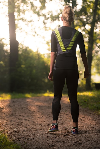 Jovem mulher correndo na área de floresta arborizada - treinamento e exercício para Trail Run Maratona Endurance - conceito de estilo de vida saudável de fitness