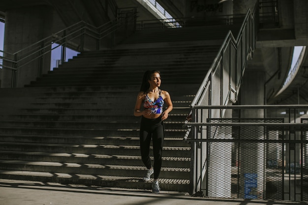 Jovem mulher correndo no ambiente urbano