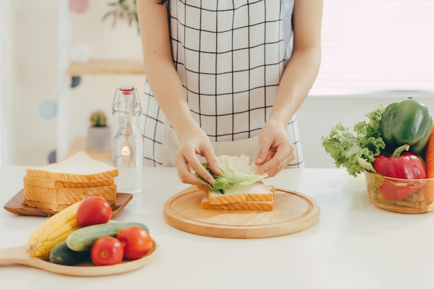 Jovem mulher cortando vegetais na cozinha