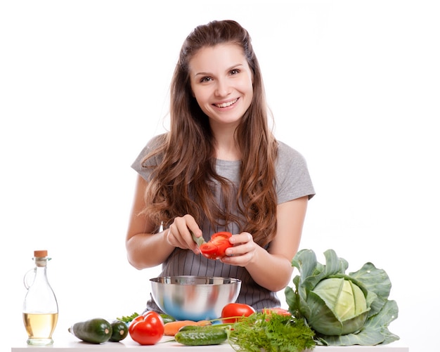 Jovem mulher cozinhando na cozinha. alimentos saudáveis - salada de legumes.