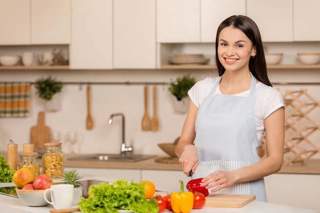 Jovem mulher cozinhando na cozinha. Comida saudável. Conceito de dieta. Estilo de vida saudável. Cozinhar em casa. Preparar comida