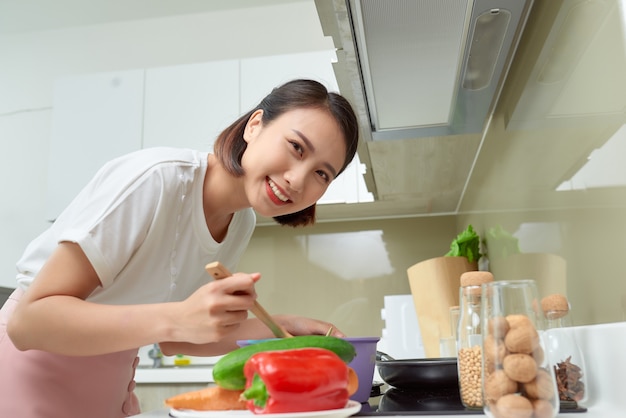 Jovem mulher cozinhando na cozinha. Comida saudável. Conceito de dieta. Estilo de vida saudável. Cozinhar em casa. Preparar comida