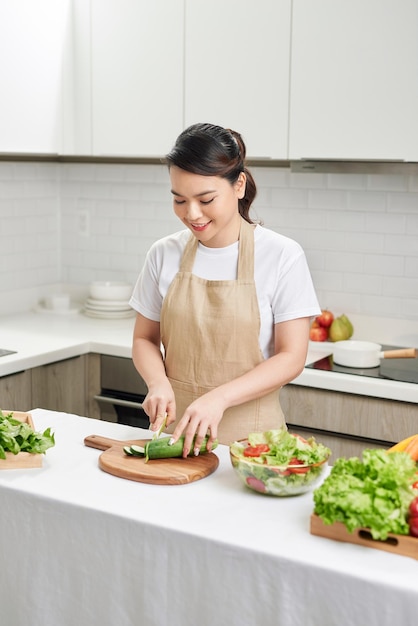 Jovem mulher cozinhando na cozinha conceito de dieta de alimentos saudáveis