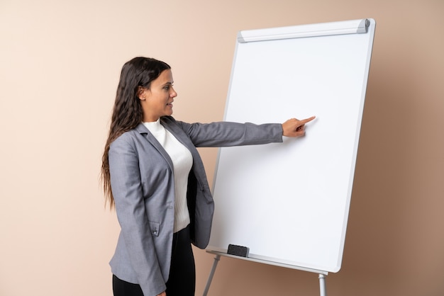 Jovem mulher dando uma apresentação no quadro branco, dando uma apresentação no quadro branco