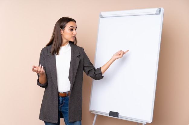 Jovem mulher dando uma apresentação no quadro branco, dando uma apresentação no quadro branco