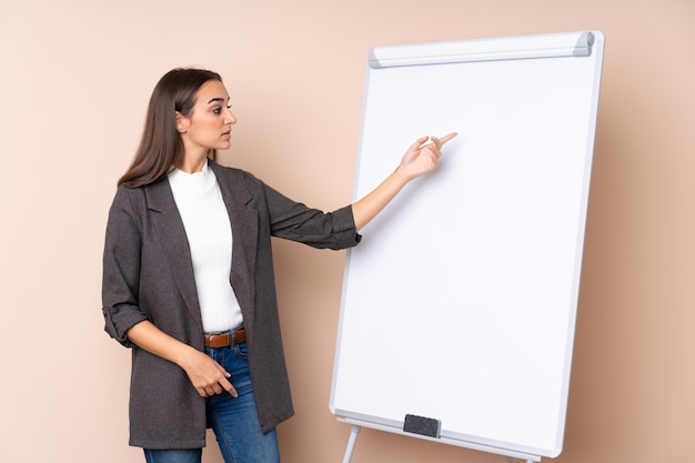 Jovem mulher dando uma apresentação no quadro branco, dando uma apresentação no quadro branco