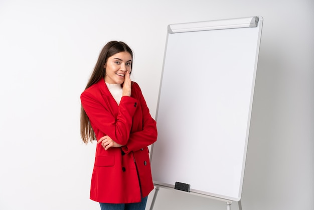 Jovem mulher dando uma apresentação no quadro branco sussurrando algo