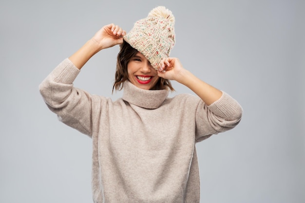 jovem mulher de chapéu e camisola de inverno de tricô