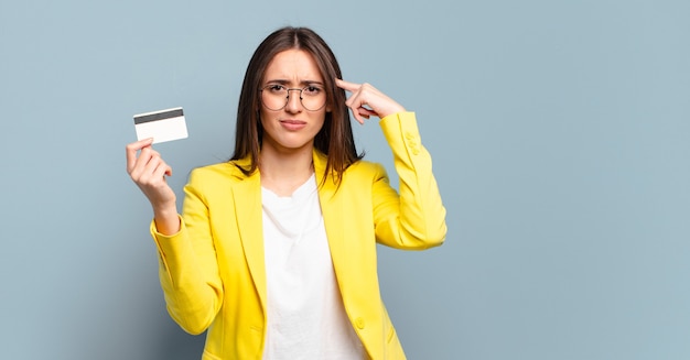 Jovem mulher de negócios bonita com cartão de crédito