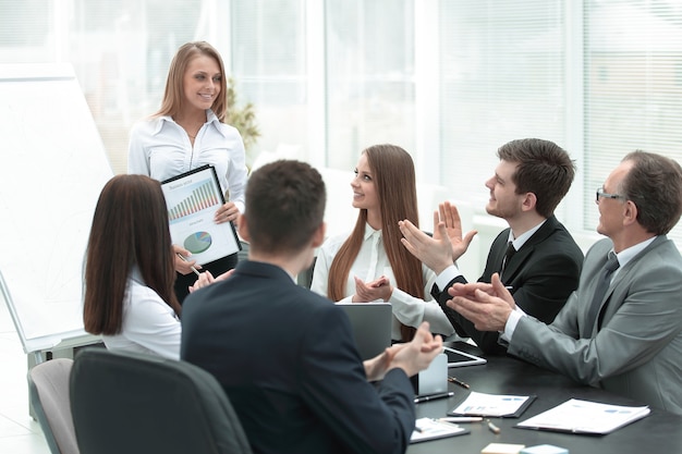 Jovem mulher de negócios fazendo uma apresentação para colegas de trabalho.