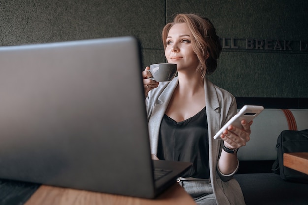 Jovem mulher de negócios feliz com laptop