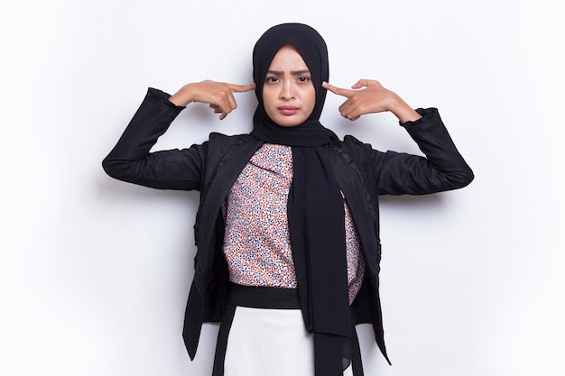 Jovem mulher de negócios muçulmana asiática cobrindo ambas as orelhas com as mãos isoladas no fundo branco