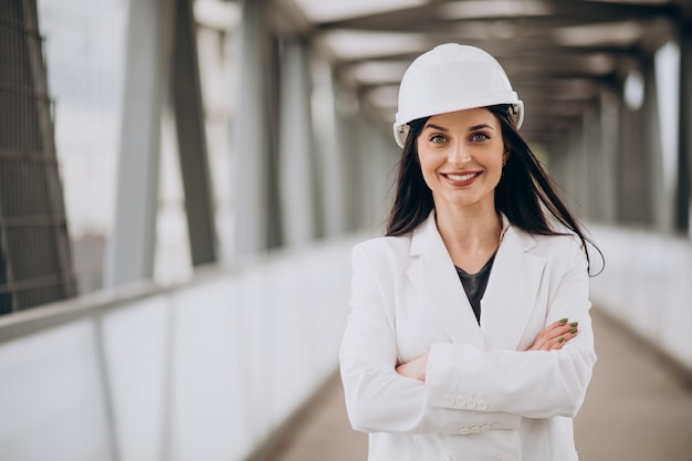 Jovem mulher de negócios usando capacete na construção de um objeto