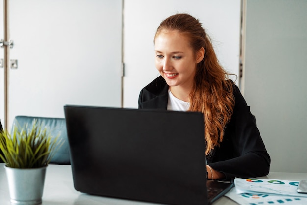 Jovem mulher de negócios usando um computador portátil