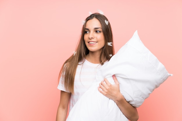 Jovem mulher de pijama sobre fundo rosa isolado sorrindo muito