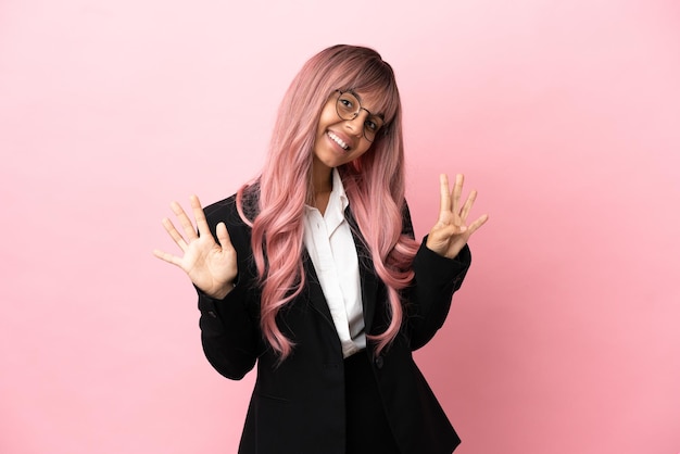 Jovem mulher de raça mista, negócios, com cabelo rosa isolada em um fundo rosa, contando nove com os dedos