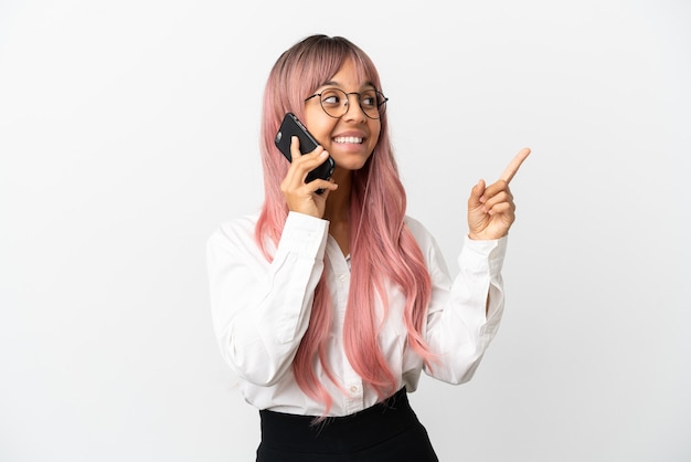 Jovem mulher de raça mista, negócios, com cabelo rosa segurando um celular isolado em um fundo rosa apontando uma ótima ideia