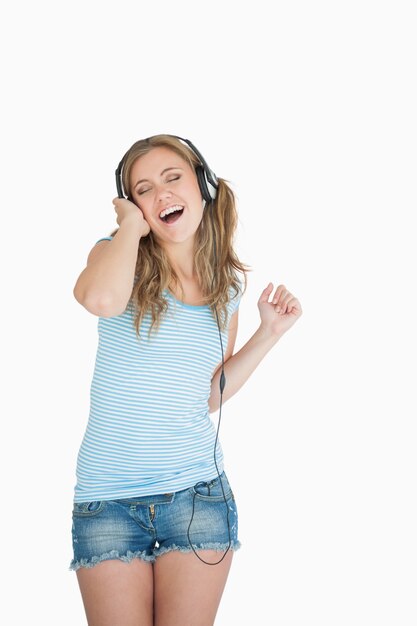 Jovem, mulher, desfrutando música por fones de ouvido