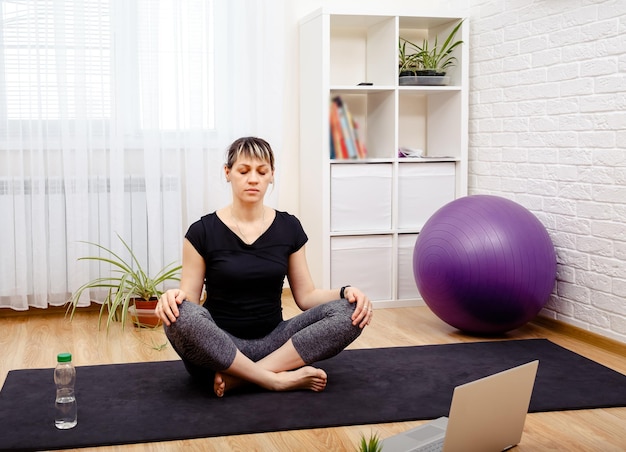 Jovem mulher desportiva praticando o conceito de meditação de atenção plena de ioga