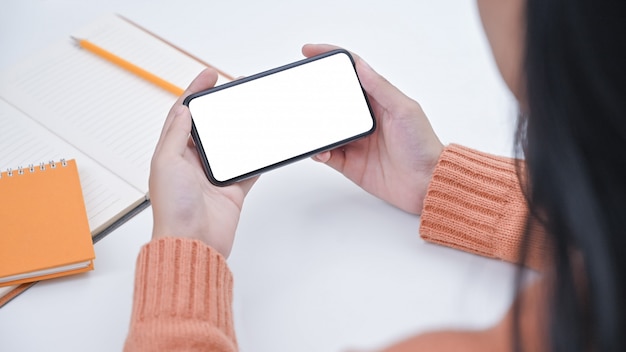 Jovem mulher do close-up que guarda o smartphone com tela isolada.