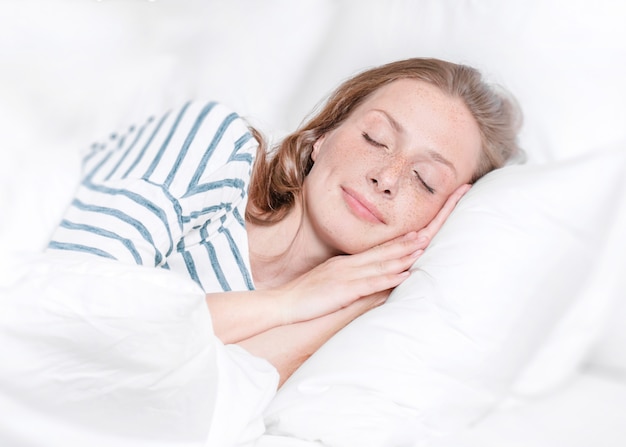 Jovem mulher dormindo na cama.